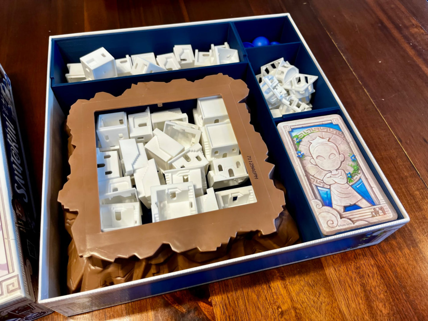 KreativLayers Santorini board game organizer with compartments for game components and cards, enhancing gameplay experience.