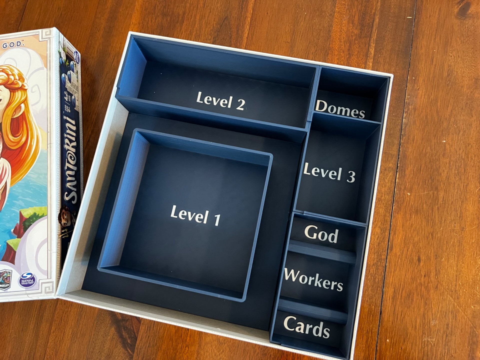 KreativLayers Santorini game insert organizer with compartments for game pieces and cards, designed for efficient storage.