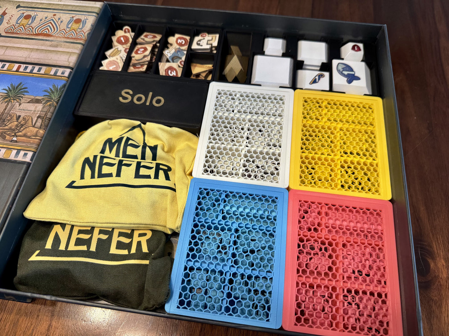 Men-Nefer board game organizer by KreativLayers, showcasing compartments for game pieces and cards in a sleek design.