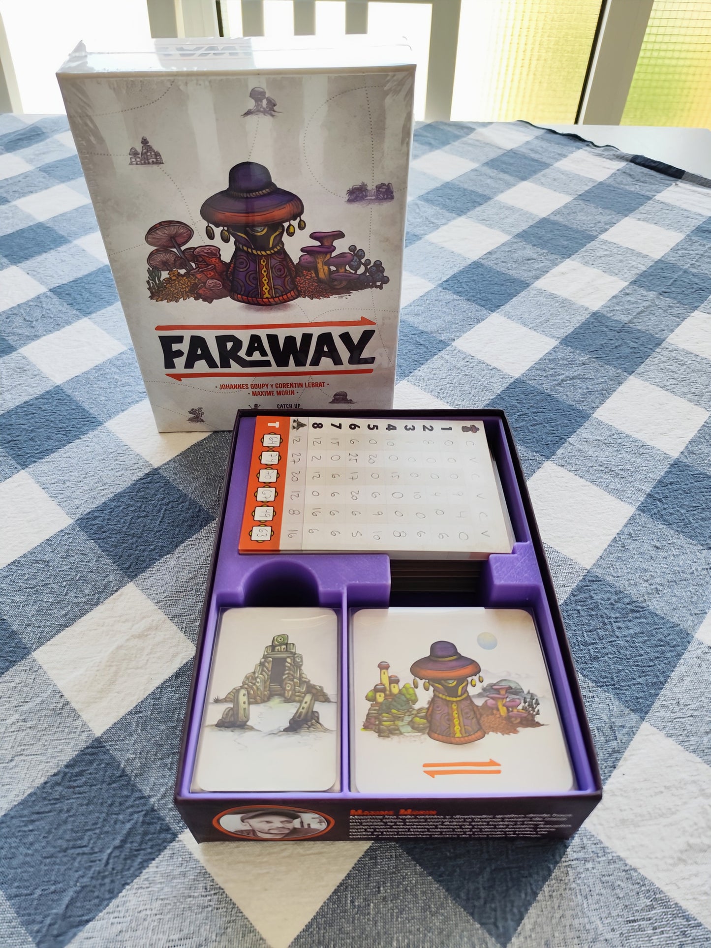KreativLayers Faraway Board Game Organizer with compartments for game pieces and cards, displayed on a wooden table.