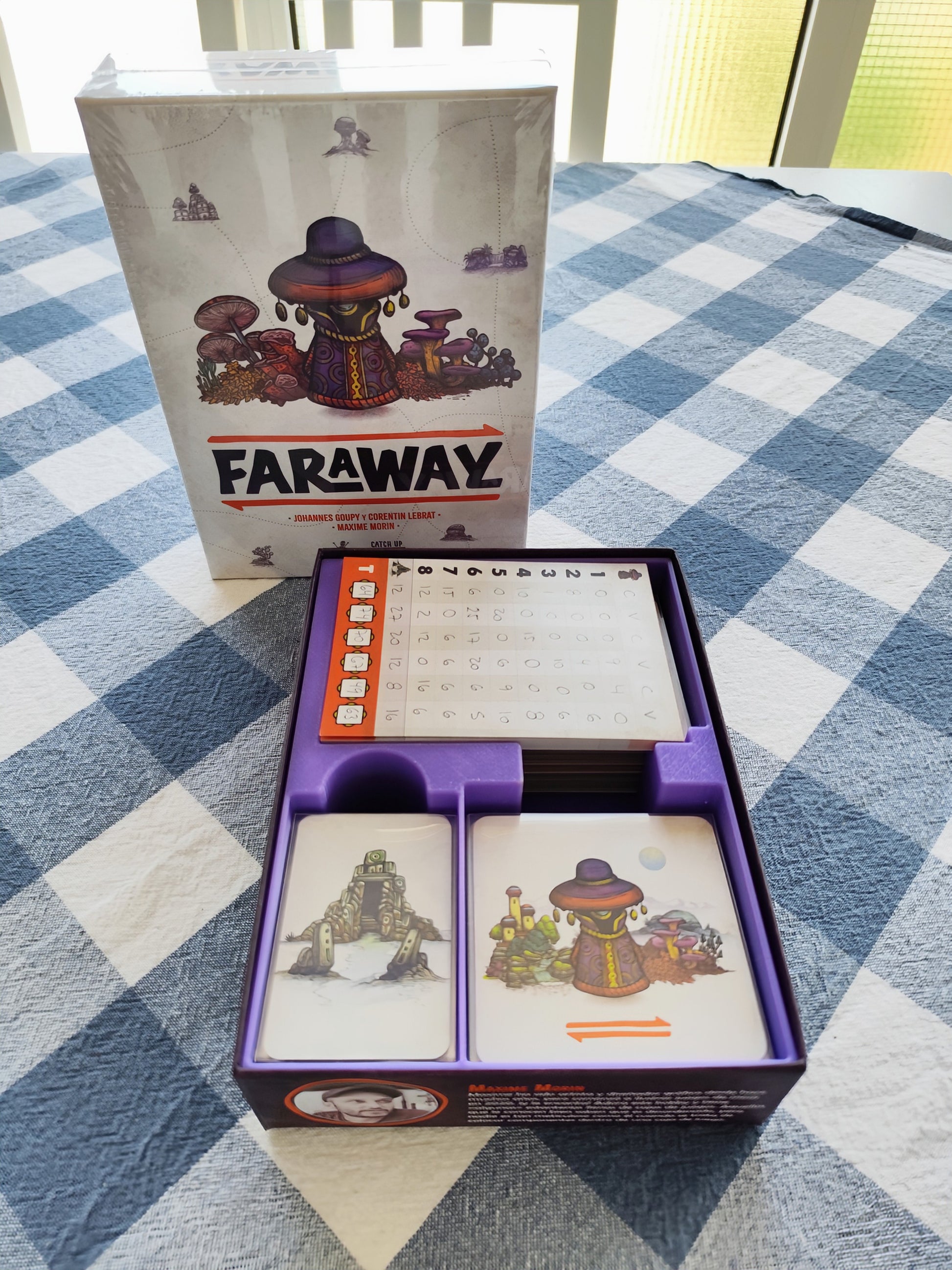 KreativLayers Faraway Board Game Organizer with compartments for game pieces and cards, displayed on a wooden table.