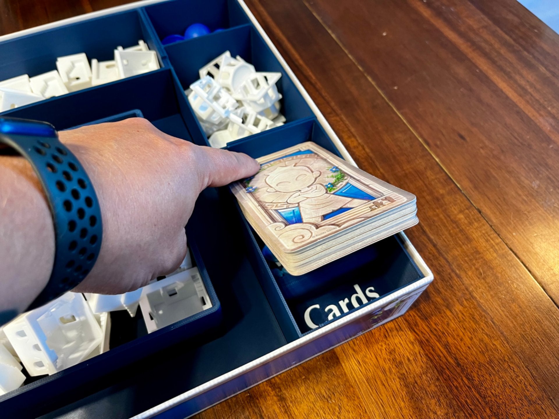 KreativLayers Santorini board game organizer with compartments for game pieces and cards in a tidy layout.