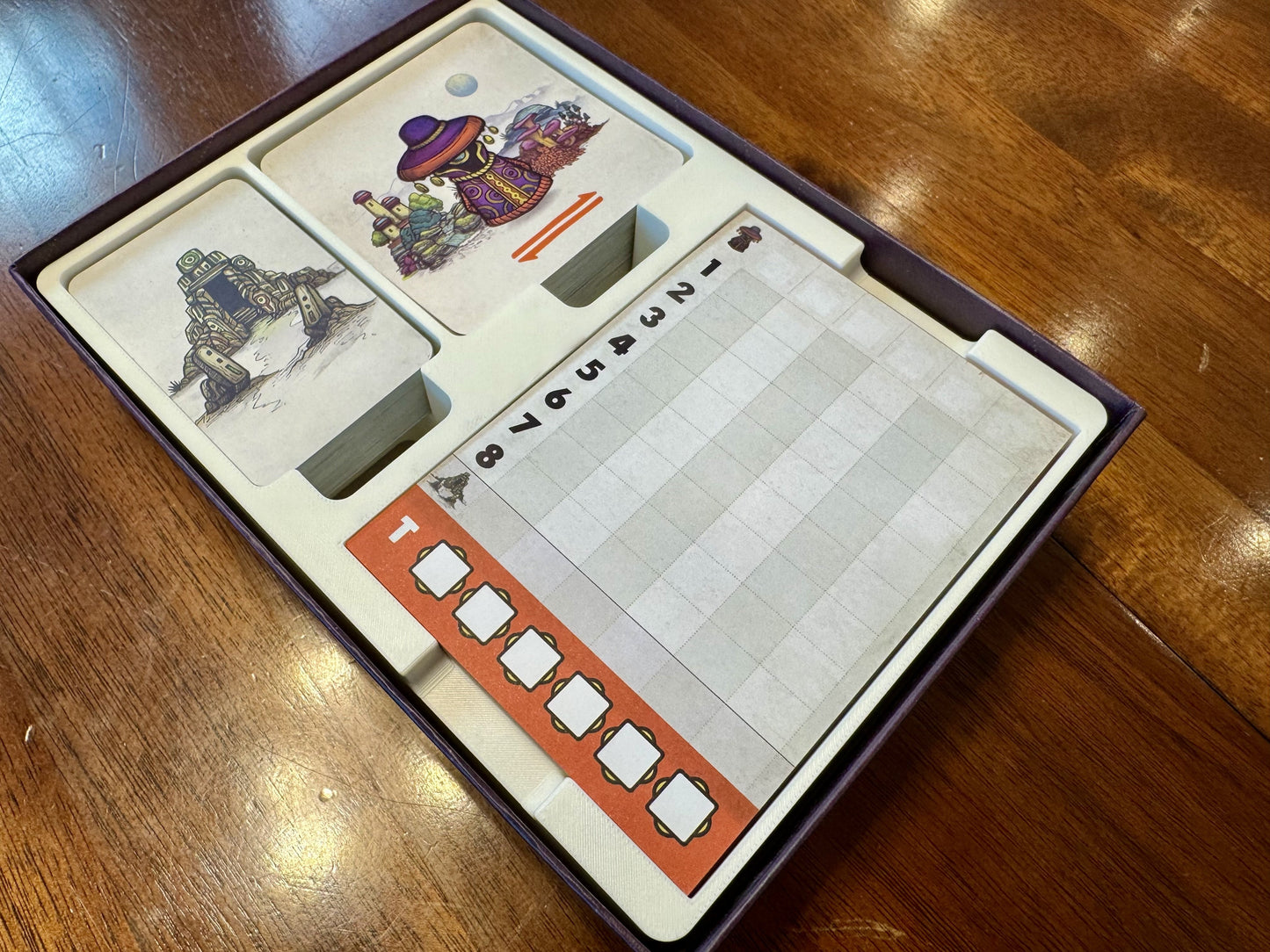 KreativLayers Faraway Game Insert, a board game organizer with compartments for game pieces and cards, displayed on a table.