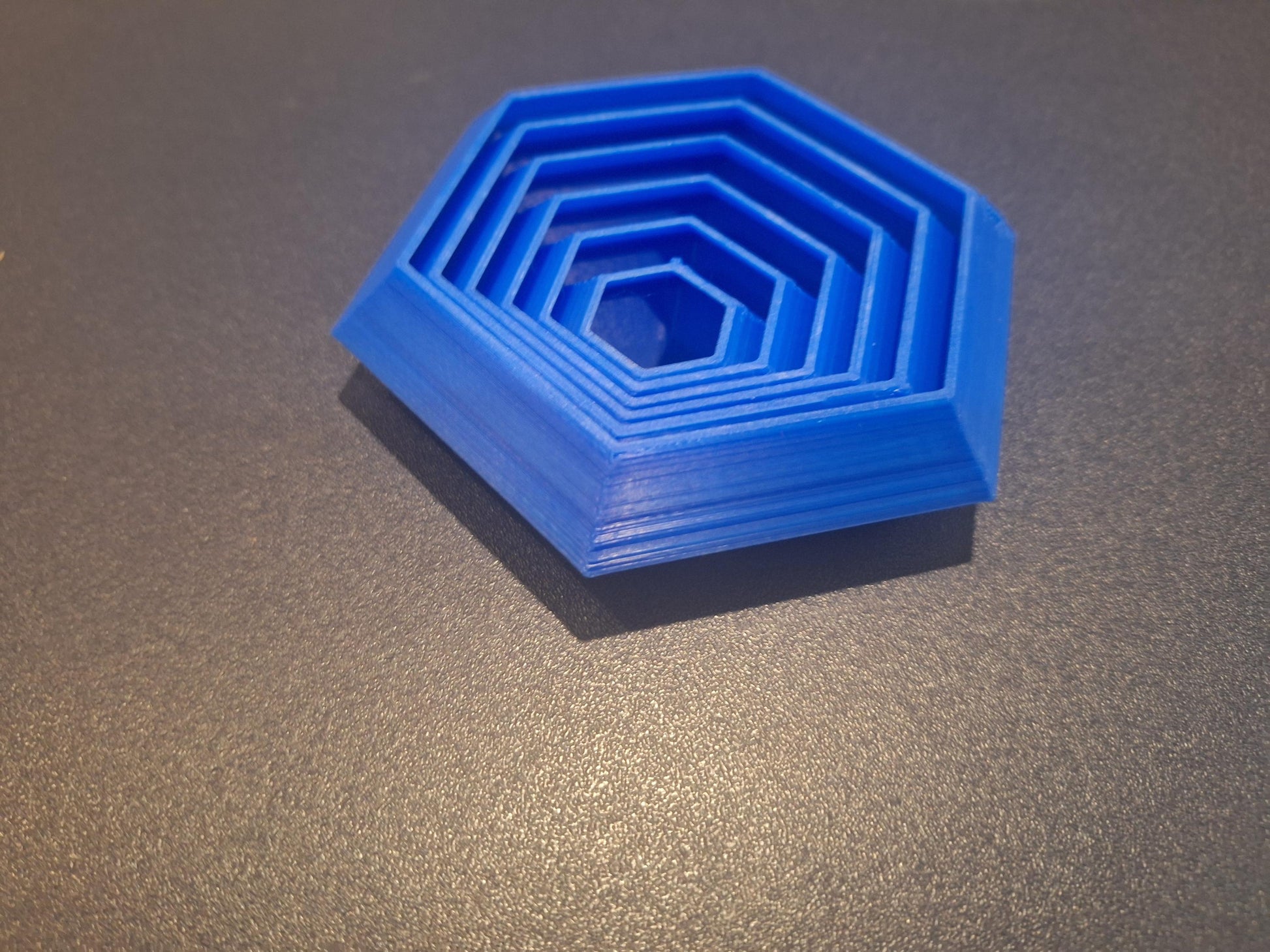 Blue 3D printed hexagonal board game organizer insert on dark surface, KreativLayers