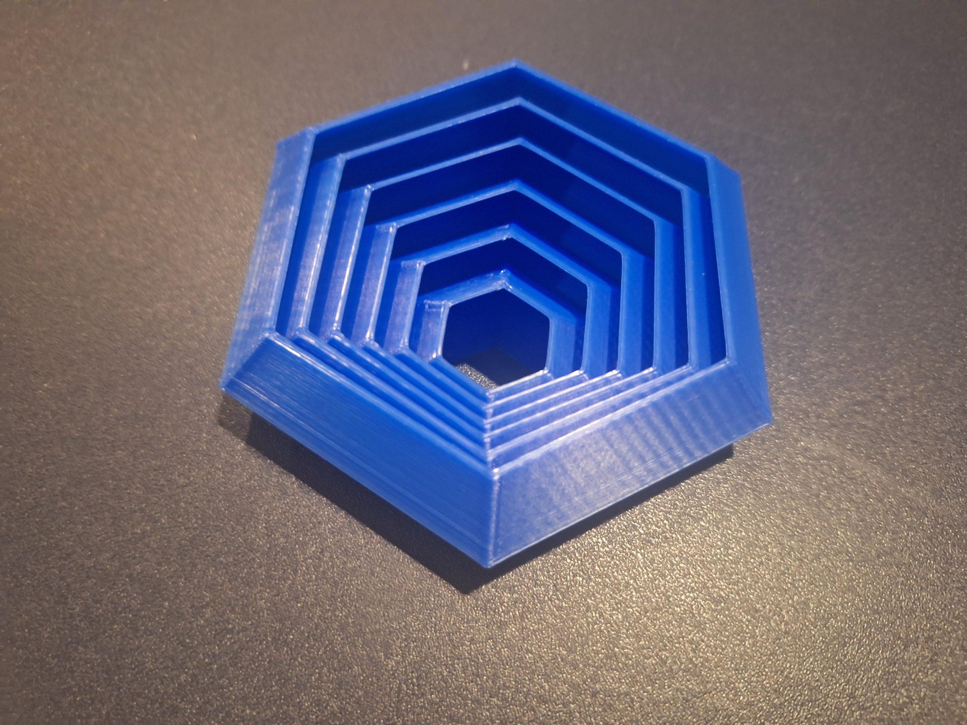 Blue 3D printed hexagonal board game organizer insert on dark surface, KreativLayers