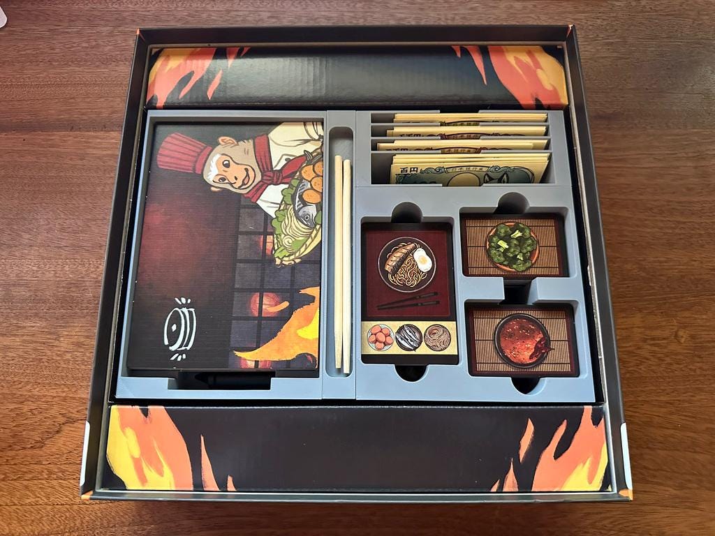 3D printed board game organizer with chef artwork, money cards, and food tokens in box by KreativLayers