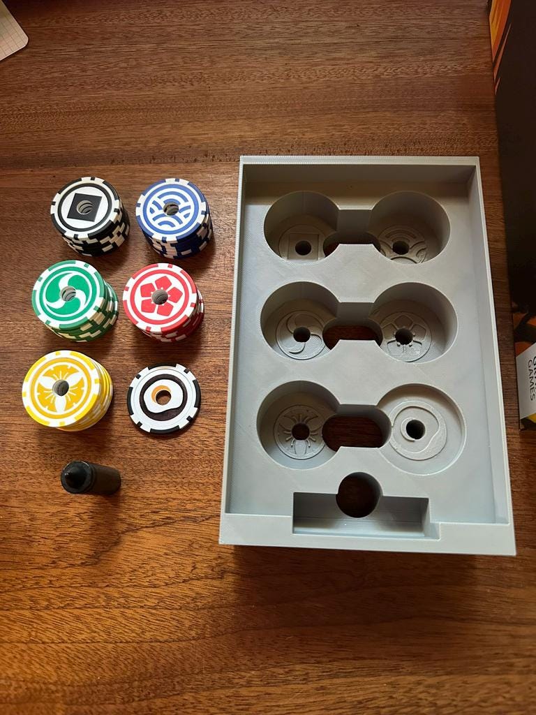 Board game organizer tray with 3D printed insert and colorful game tokens on wood table