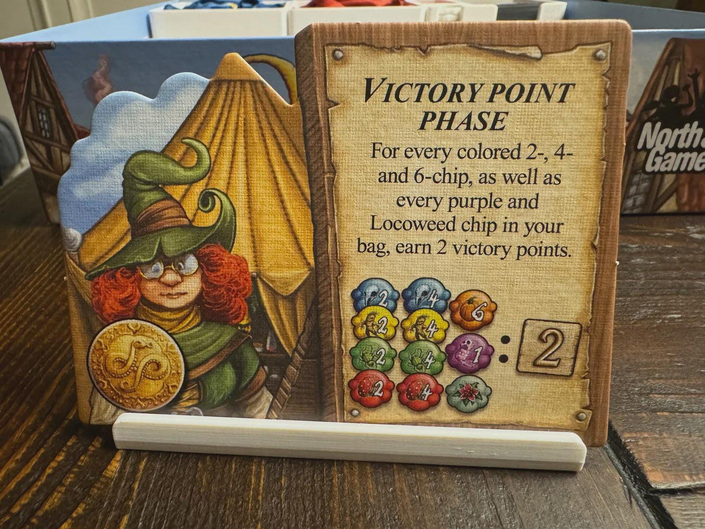 Board game organizer with illustrated wizard character and victory point phase instructions card