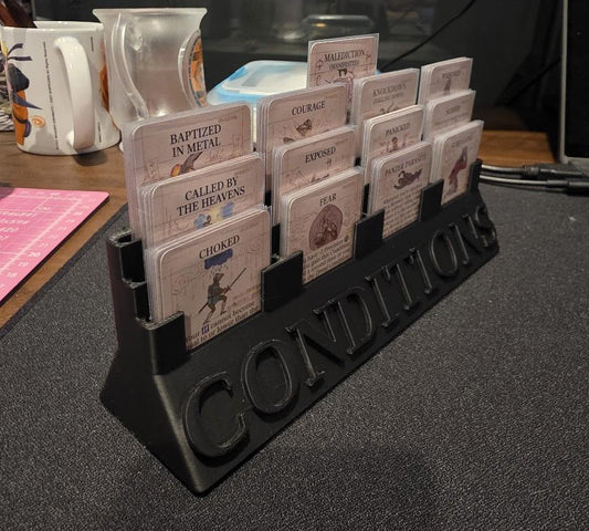 Tabletop game condition cards organized in a black plastic holder labeled 'CONDITIONS'.