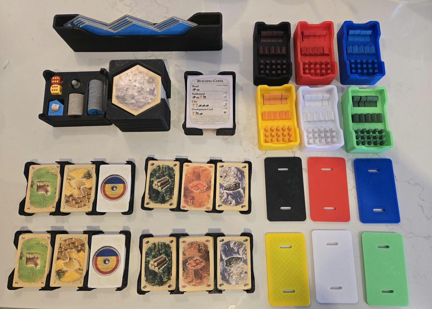 KreativLayers 3D printed board game organizer with color-coded boxes, card holders, and game components neatly arranged.