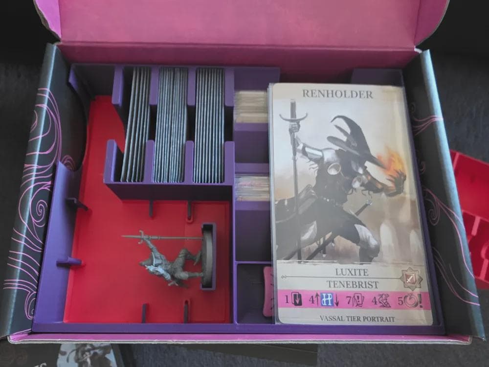 Board game organizer insert with sorted cards, game piece, and character card in game box