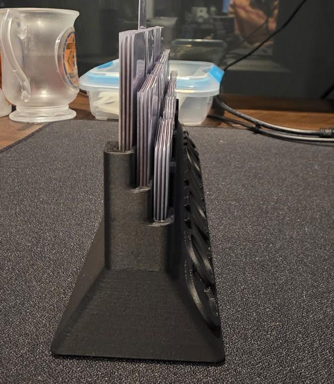 Black 3D printed card holder organizer on desk with trading cards