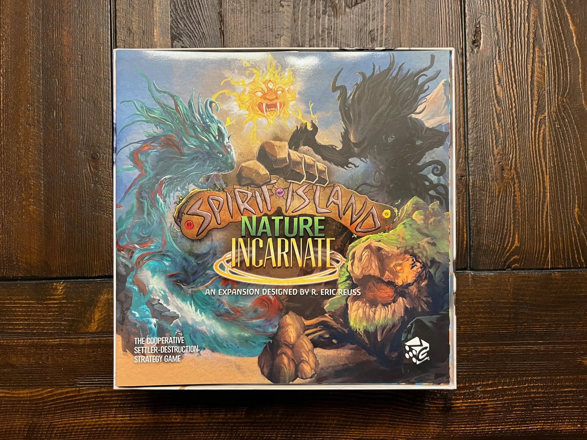 Spirit Island Nature Incarnate board game expansion box on wooden table, vibrant illustrated cover