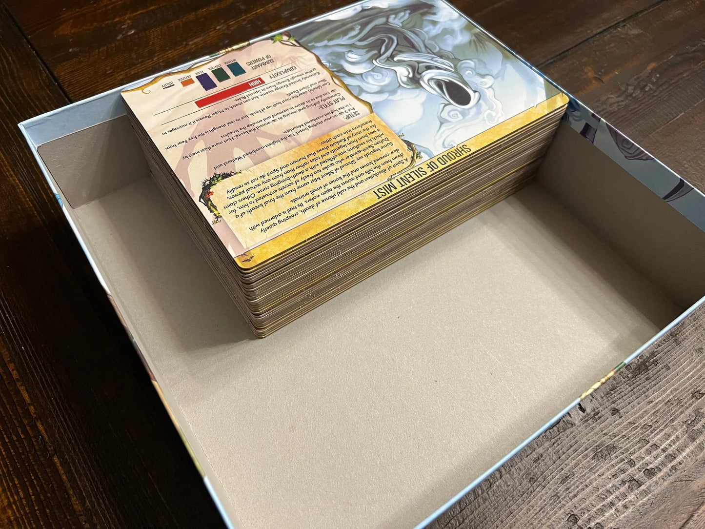Board game cards neatly stacked inside a game box, showing tabletop game organization.