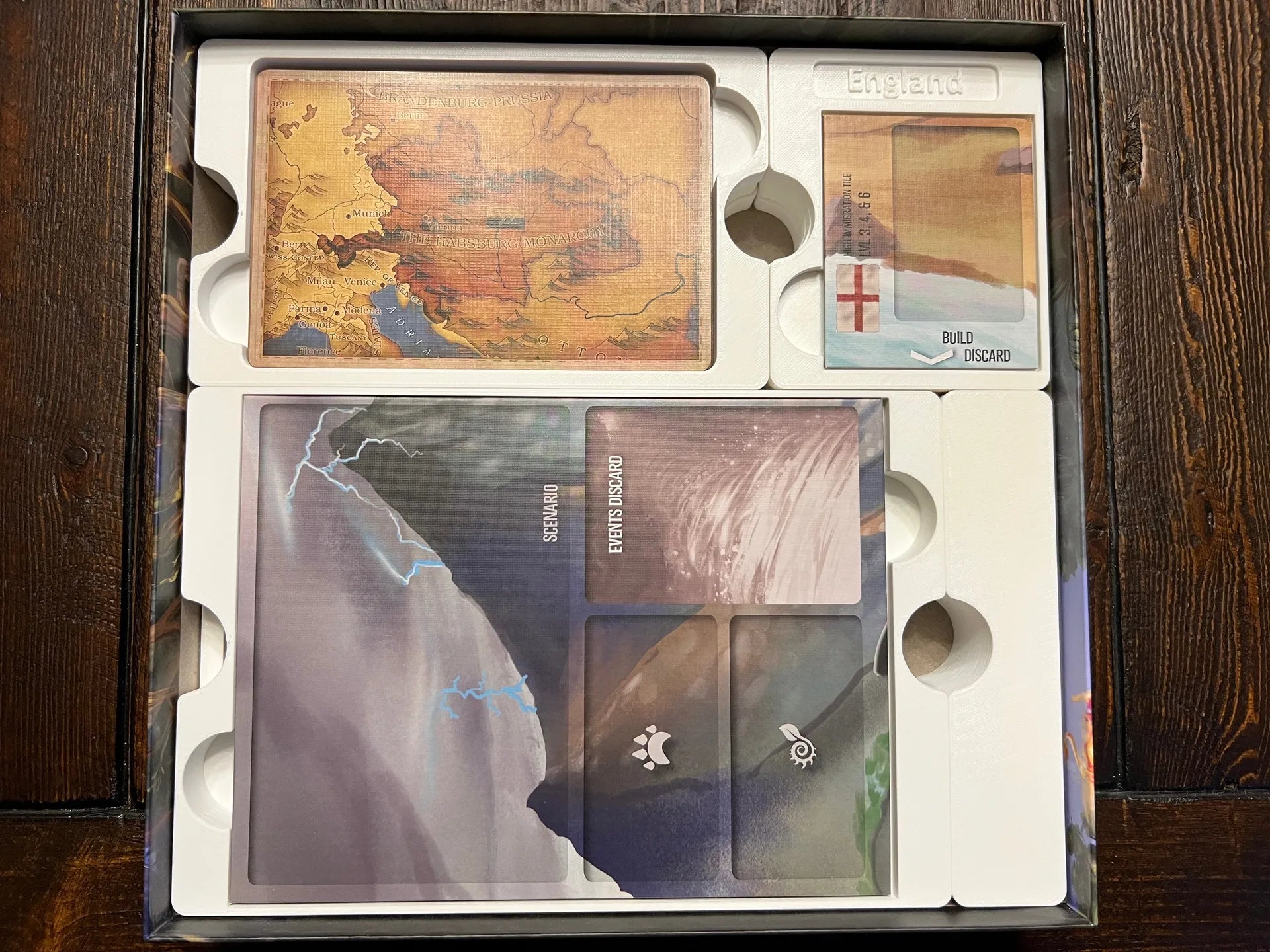 Board game organizer insert holding game cards, scenario sheets, and components neatly stored.