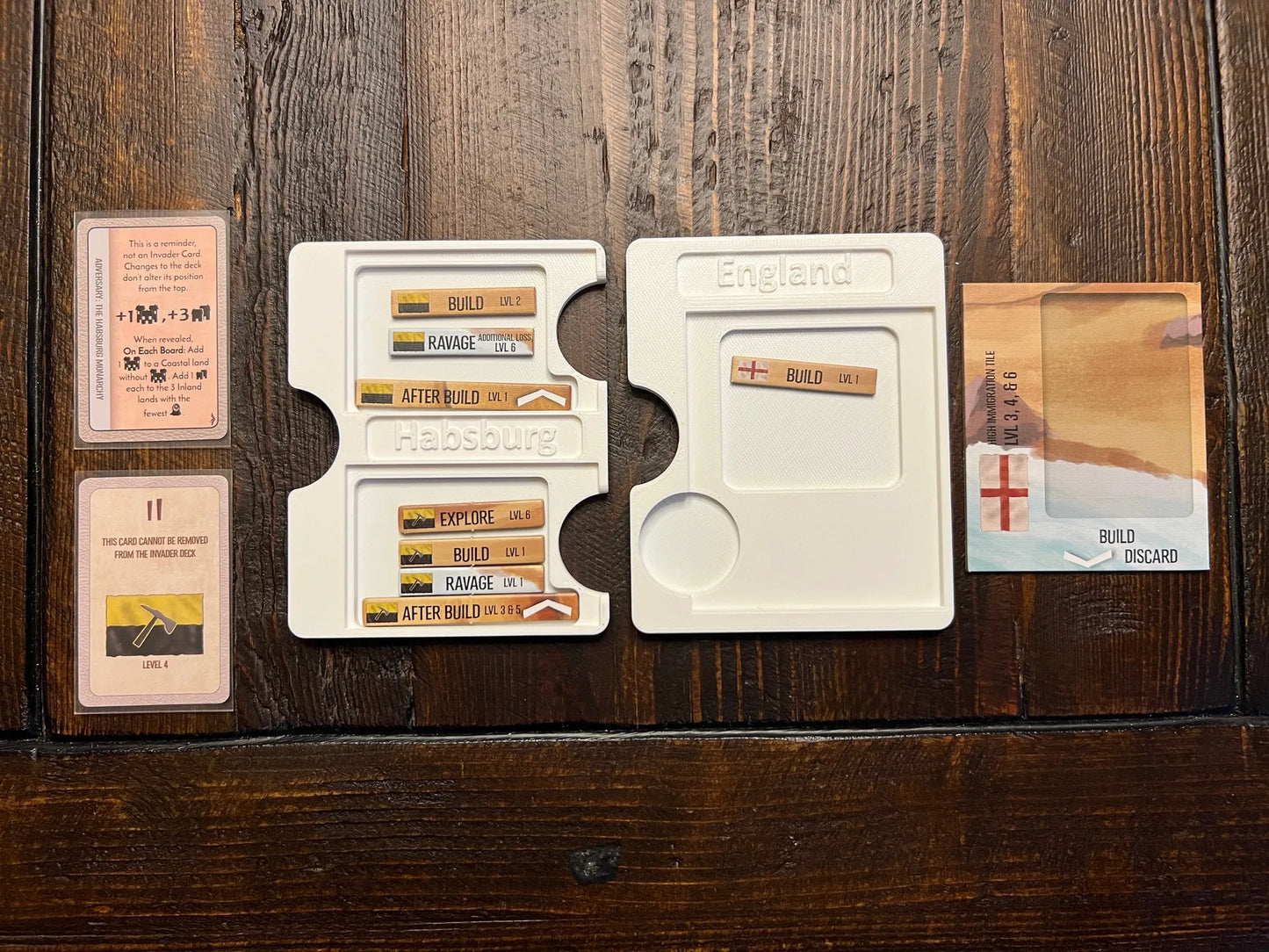 Board game organizer inserts from KreativLayers holding game cards and tokens on wood table.